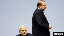 Pakistani Prime Minister Nawaz Sharif walks past his Indian counterpart Narendra Modi (foreground) during the opening session of 18th South Asian Association for Regional Cooperation (SAARC) summit in Kathmandu November 2014.