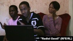 Aspiring Nigerian soccer player Dennis Tahgbok (center) discusses his situation from a flat in Dushanbe.