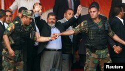 Президент Мухаммад Мурси президенттик гвардиянын күзөтчүлөрүнүн кайтаруусунда. Каирдин Тахрир аянты, 29-июнь 2012