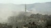 Smoke rises above buildings following what many say was a toxic gas attack by Syrian forces on the outskirts of Damascus on August 21.