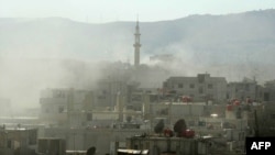 Smoke rises above buildings following what many say was a toxic gas attack by Syrian forces on the outskirts of Damascus on August 21.