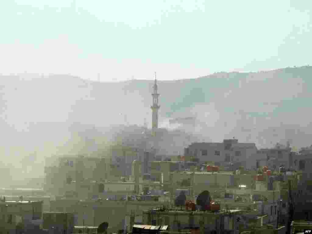 Гута, пригород Дамаска. Над домами поднимается дым. В этот день, 21 августа 2013 года, по заявлению сирийской оппозиции, правительственные войска осуществили здесь химическую атаку, применив отравляющие газы. &nbsp; &nbsp;