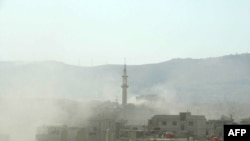 Smoke rises following what Syrian rebels claim to be a toxic-gas attack by pro-government forces on the outskirts of Damascus on August 21.