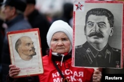 A supporter of the Russian Communist Party holds portraits of Vladimir Lenin (left) and Josef Stalin during a procession to mark Defender of the Fatherland Day in Moscow on February 23.