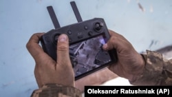 Украинский военнослужащий смотрит на экран дрона, показывающий позиции российских войск