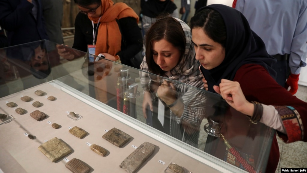 Journalists look at ancient clay tablets that were returned to Iran from the United States at the National Museum in Tehran in 2019.