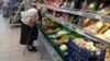 RUSSIA -- An elderly woman chooses vegetables in a supermarket in Dmitrov, a Russian town 75 km., (47 miles) north from Moscow, Russia, Saturday, July 2, 2016.