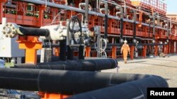 Рабочий на территории нефтедобывающего предприятия. Иллюстративное фото.