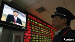 A security guard in Huaibei watches a screen showing newly appointed Communist Party General Secretary Xi Jinping speaking during a news conference.