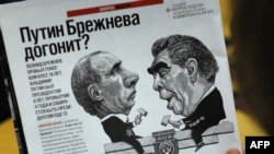 A man looks at a cartoon depicting Premier Vladimir Putin (left) and former Soviet leader Leonid Brezhnev in a magazine in Moscow.