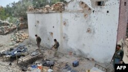 Security personnel inspect a damaged police post following an airstrike in Bati Kot district in Nangarhar province, August 1, 2013