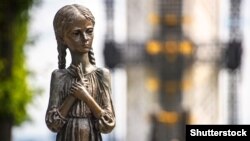 A sculpture of a girl and part of the memorial to the victims of the Holodomor in Kyiv.