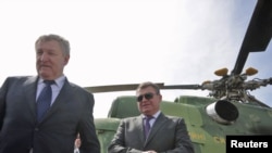 Министр обороны Украины Михаил Ежель (слева) и его российский коллега Анатолий Сердюков во время посещения военной базы возле города Саки, 18 апреля 2011 года