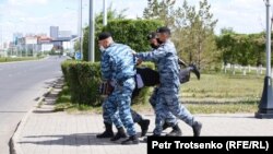 Арнайы жасақ митингіге келгендердің бірін әкетіп барады. Нұр-Сұлтан, 6 маусым 2020 жыл.