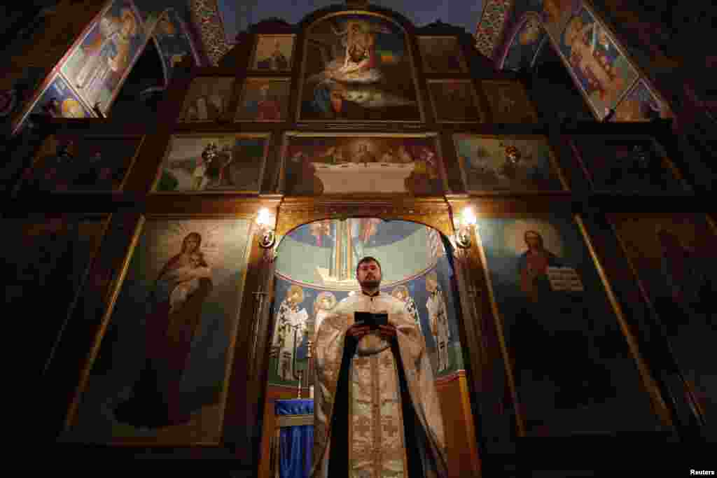 In Bosnia-Herzegovina, Serbian Orthodox Priest Bojan Glisic prays on the eve of Orthodox Christmas in the central Bosnian town of Zenica.