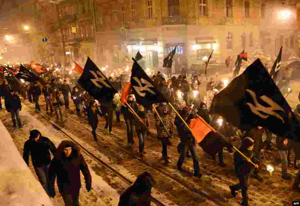 Nationalists, carrying torches, march in the western Ukrainian city of Lviv to mark the 95th anniversary of a battle near the small city of Kruty. Some 300 students, cadets, and schoolboys were killed in a battle against the Red Army on January 29, 1918, to protect the newborn Ukrainian People&#39;s Republic against Bolshevik aggression. (AFP/Yuriy Dyachyshyn)