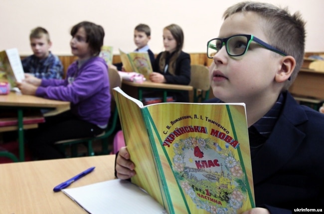 Gli alunni di quarta ascoltano durante una lezione di lingua ucraina presso la scuola secondaria di Vyshneve, nella regione di Kiev.