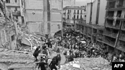 Firemen, policemen and rescuers search as wounded people after a bomb exploded at the Argentinian Israelite Mutual Association (AMIA) in Buenos Aires, 18 July 1994