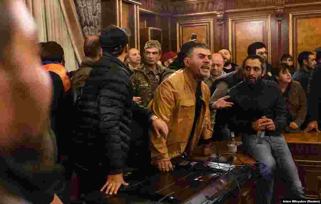 Протестующие в здании правительства. Премьер-министр Никол Пашинян попытался возложить вину за потери в Нагорном Карабахе на предыдущее правительство. Он заявил: &quot;Мы должны готовиться к возмездию. Мы не реагировали должным образом на коррумпированных, олигархических мерзавцев, которые грабили нашу страну, крали у солдат еду, крали у них оружие&quot;.