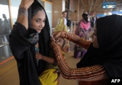 Пәкістандық медицина қызметкері анасының қолындағы сәбиге полиомиелит ауруына қарсы дәрі тамызып жатыр. Карачи әуежайы, Пәкістан, 7 мамыр 2014 жыл.