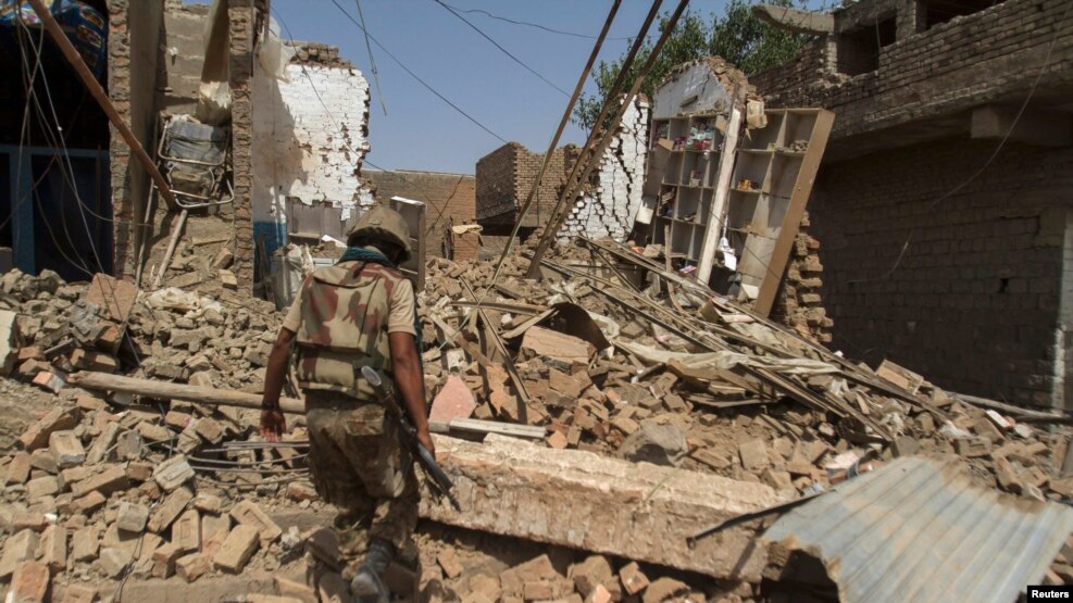 FILE: A Pakistani soldier walks in a house destroyed during a military operation in the of town of Miran Shah, North Waziristan in July 2014.