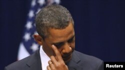 U.S. -- U.S. President Barack Obama wipes his eye as he addresses the crowd at the "Together We Thrive: Tucson and America" event at the University of Arizona in Tucson, Arizona, 12Dec2011