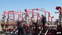 Iraqi laborers work at the Halfaya oil field near the southern city of Amara.