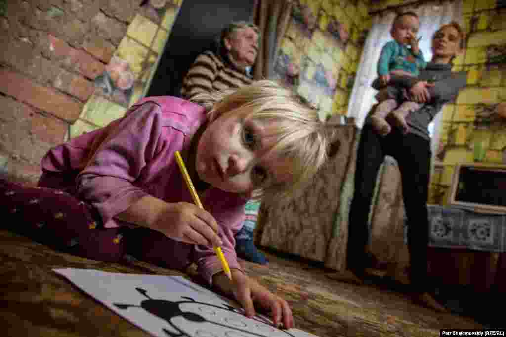 Masha draws pictures at her home in the Petrovskiy district of Donetsk. Her family was among some 40 people, including 19 children, who lived in a bomb shelter for more than a year. In spite of the cease-fire agreement that went into force in February 2015, sporadic bombing and shelling have continued, and residents are still afraid to sleep in their own homes at night.