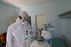 Një doktor në Klinikën Infektive qëndron pranë disa bocave të oksigjenit, të cilat përdoren për trajtimin e pacientëve me COVID-19, që janë të shtrirë në këtë klinikë.