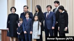 Shavkat Mirziyoev (second from left) poses for photographers with his family, including daughter Saida (center top), at a polling station after voting in Tashkent in December 2016.