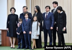 Исполняющий обязанности президента Узбекистана Шавкат Мирзияев (3-й слева) позирует фотографам со своей семьей на избирательном участке после голосования на президентских выборах в Ташкенте 4 декабря 2016 года.