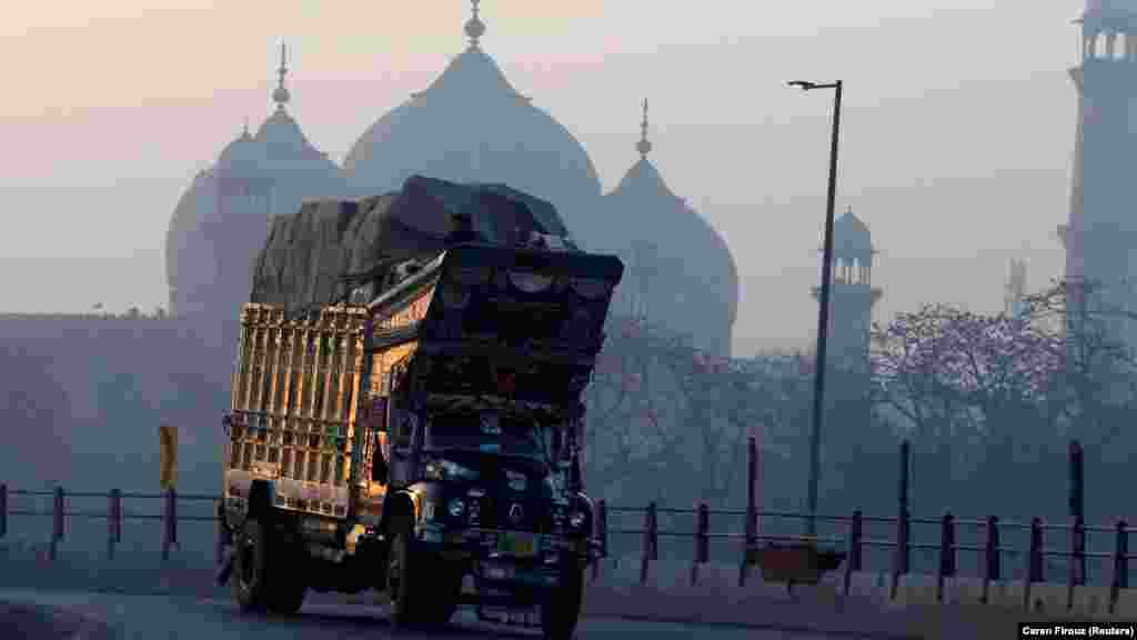 Pakistanyň Lahore şäherinde Badşahi metjidiniň öňünden bir ýük ulagy geçip barýar. (Reuters/Caren Firouz)