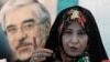 Zahra Rahnavard, wife of the leading reformist presidential candidate Mir Hossein Moussavi (shown in poster), speaks with media in a press conference in Tehran, Iran, Sunday, June 7, 2009.