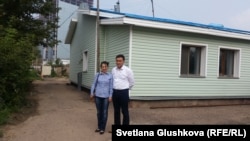 Гульшат и Жандос Курмановы стоят возле своего дома, сзади которого стройка комплекса «Абу-Даби Плаза». Астана, 26 июля 2016 года.