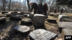 People visit a destroyed Jewish cemetery in March near a memorial to Jews killed in Minsk's Jewish ghetto during the Nazi occupation.