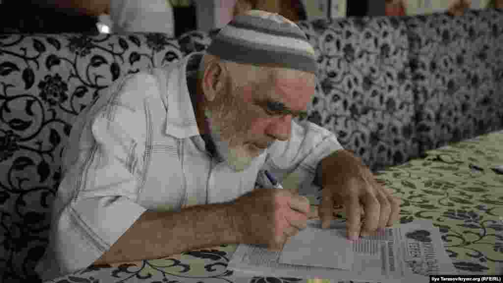 Пожилой активист пишет письмо политзаключенному