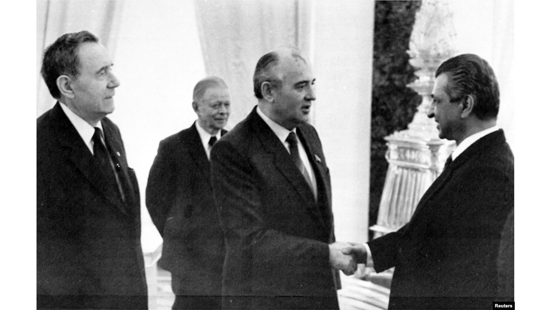 Karmal shakes hands with Soviet leader Mikhail Gorbachev (center) on a visit to Moscow in 1985.