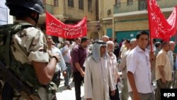 An Iraqi soldier stands guard as Iraqi journalists rally in Baghdad on August 14