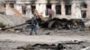 Un localnic trece prin fața unei clădiri avariate în orașul Trosteaneț, la aproximativ 400 km est de Kiev, 28 martie 2022.
