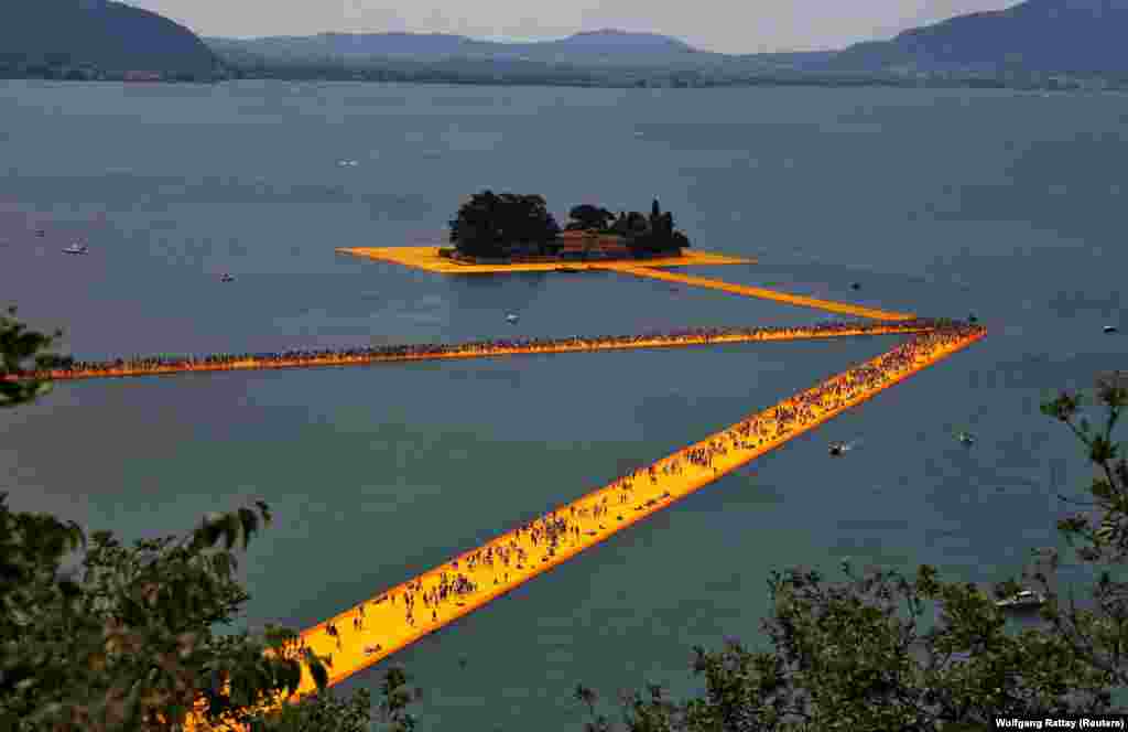 People walk on The Floating Piers