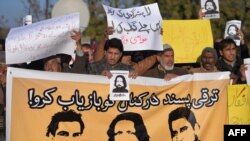 Pakistani human rights activists hold images of bloggers who are missing during a protest in Islamabad on January 10.