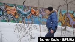 Қабырғаға салынған кескіндеме граффитиге қарап тұрған адам. Алматы, 27 ақпан 2013 жыл