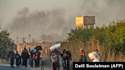 Civilians flee with their belongings during Turkish bombardment on Syria's northeastern town of Ras al-Ain in the Hasakeh province along the Turkish border. October 9, 2019