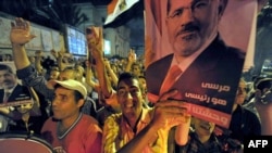 Supporters of Egypt's deposed president, Muhamad Morsi, hold up his image during a protest in the Mediterranean city of Alexandria late on August 5.