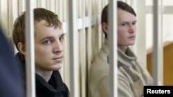 Opposition activists Zmitser Dashkevich (left) and Eduard Lobau sit inside a guarded cage during a court hearing in Minsk on March 24.