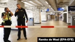 Dutch police officers stand at the scene of a stabbing attack near Amsterdam's Central Station on August 31.