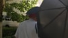 Kazakhstan - Someone with umbrella interferes to RFERL reporter - Shymkent - Dilara Isa