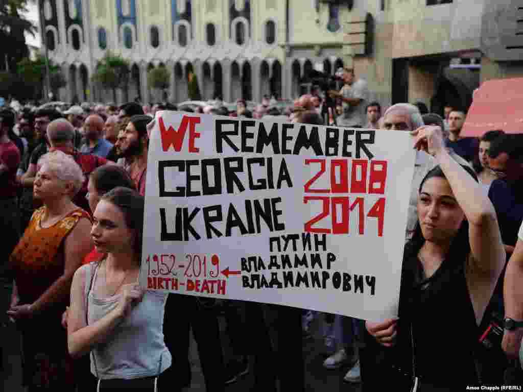 Activists' signs are referring to Georgia's 2008 conflict with Russian forces over the breakaway regions of South Ossetia and Abkhazia, when Russian tanks drove near Tbilisi, as well as the ongoing conflict in eastern Ukraine. Among the protesters' demands is the resignation of the country's interior minister, Giorgi Gakharia.