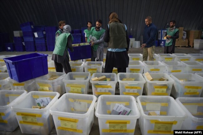 Afghan employees of the Independent Election Commission load biometric devices in to boxes at a warehouse in Kabul on October 10.