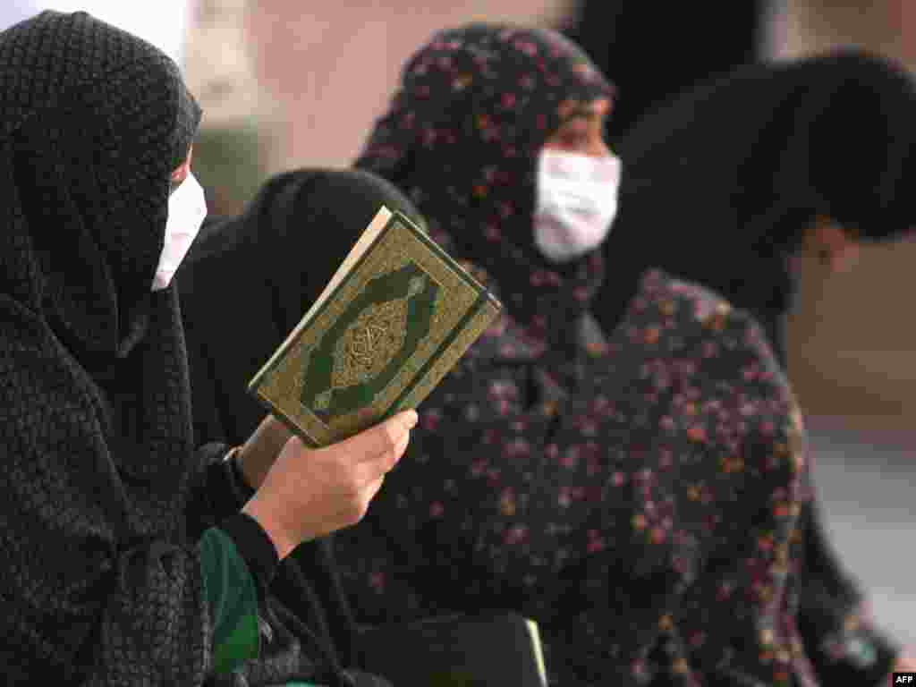 Saudijska Arabija - Hodočasnici - Muslimanke, hodočasnice sa zaštitnim maskama na licu u molitvi ispred džamije u Medini. 